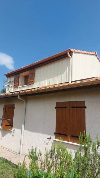 Finitions soignées en aluminium ton pierre pour une façade moderne.