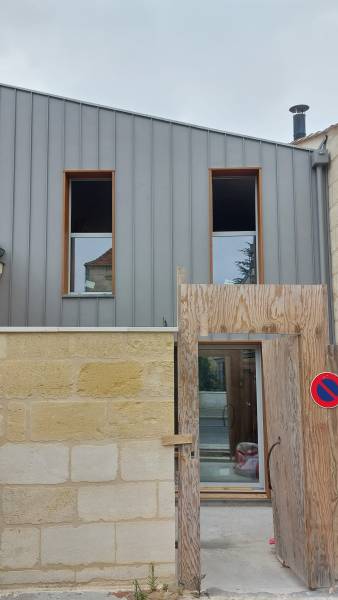Vue d’ensemble de la maison rénovée avec un habillage en aluminium gris antique, alliant esthétique et durabilité.